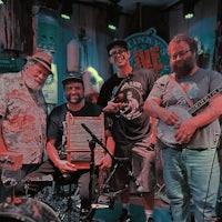 a group of men posing for a picture in a bar